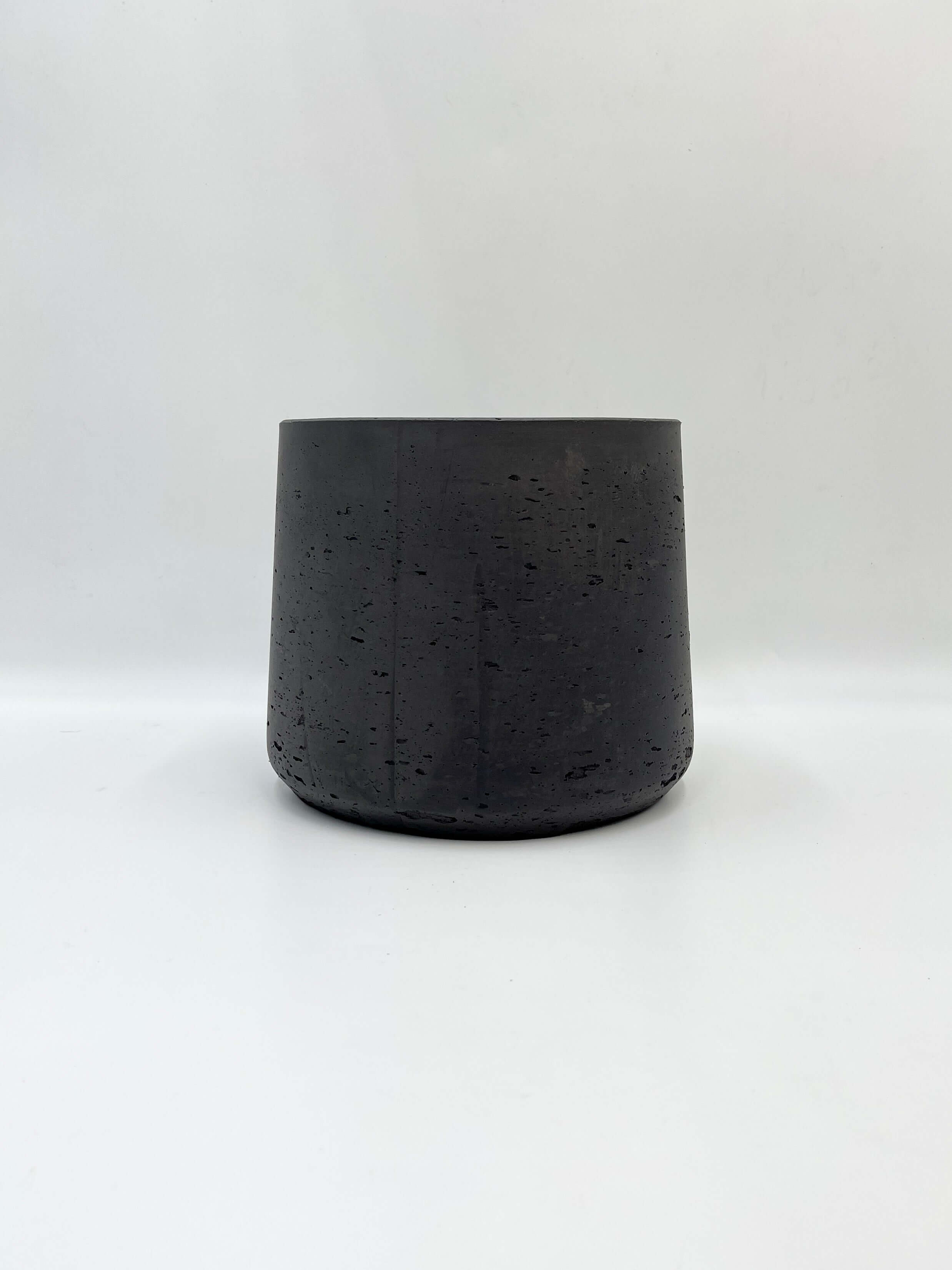 Minimalist black plant pot with a rough finish, perfect for indoor or outdoor use, 17cm cylindrical design.